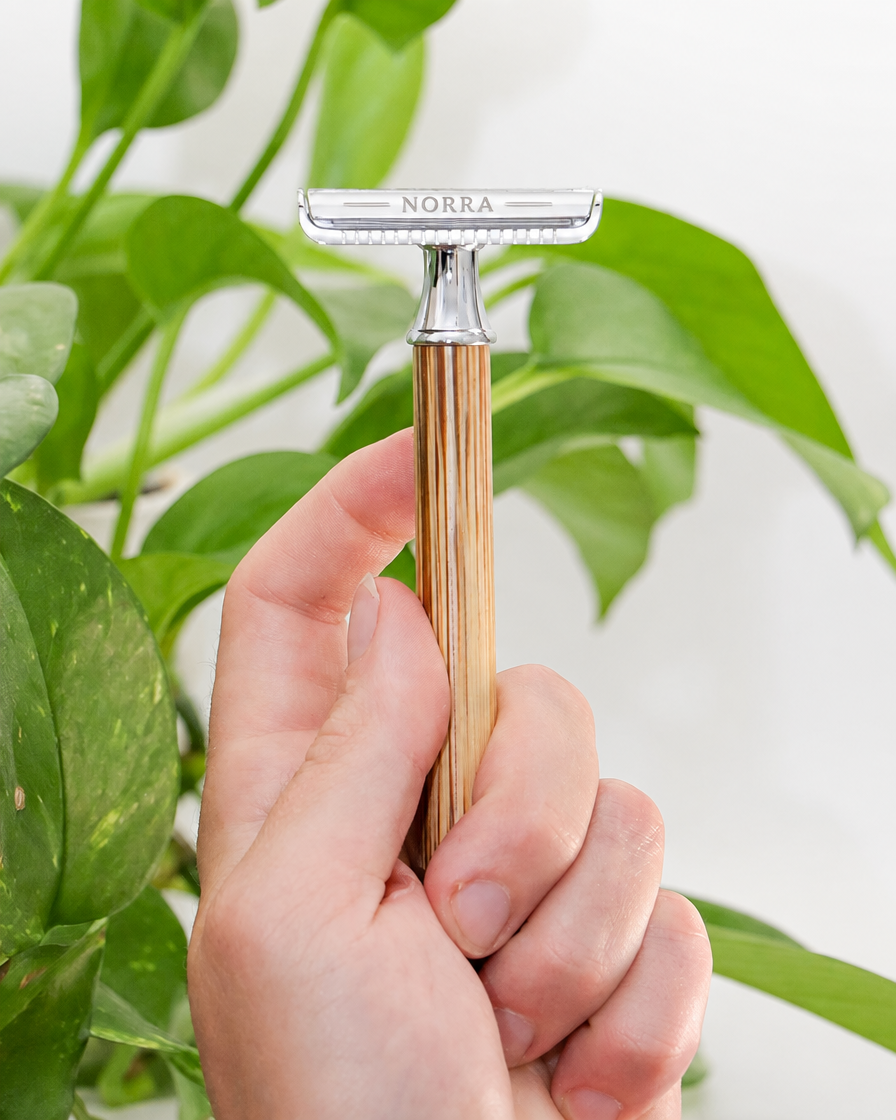 Rasoir Héritage bambou tenu en main, plante verte
